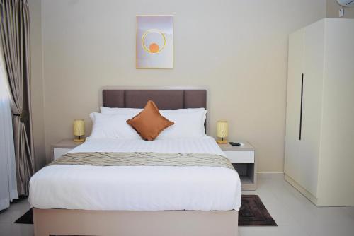 a bedroom with a large bed with white sheets at Ken Koral Bed and Breakfast in Gaborone