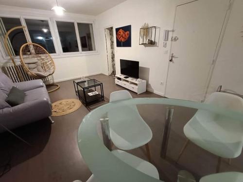 un salon avec une table en verre et un canapé dans l'établissement Appartement 3 chambres - Drapeau, à Dijon