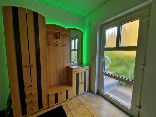 a bathroom with green lighting and a window at Ferienwohnung Esther in Naila