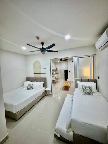 a bedroom with two beds and a ceiling fan at The Shore Suite seaview balcony Free Wifi & Netflix in Kota Kinabalu