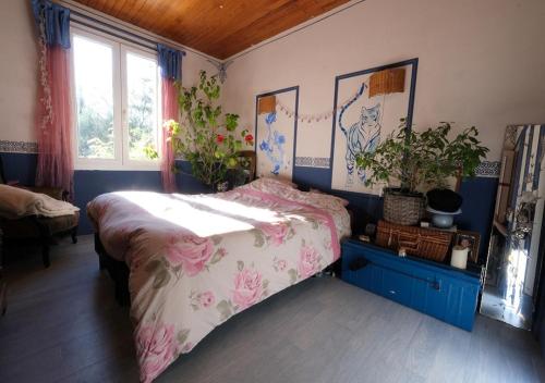 a bedroom with a bed with pink flowers on it at jolie location, maison avec piscine et joli jardin fleuri, à oppède dans le luberon en provence – 6 personnes in Oppède