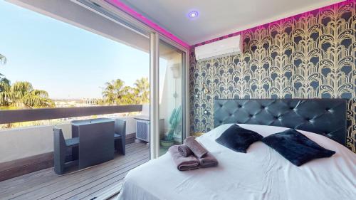 une chambre avec un lit et un balcon dans l'établissement Village Naturiste Cap d'Agde, Studio Luxe Port Nature 7, au Cap d'Agde