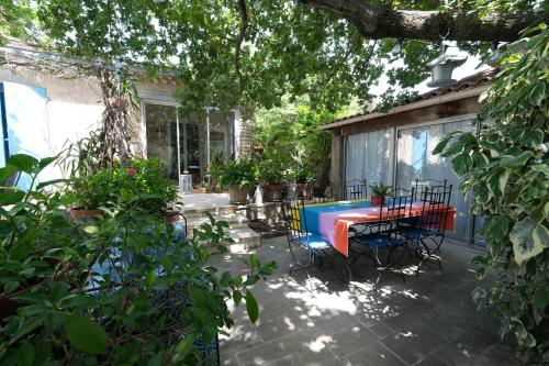 a patio with a table and chairs in a yard at jolie location, maison avec piscine et joli jardin fleuri, à oppède dans le luberon en provence – 6 personnes in Oppède