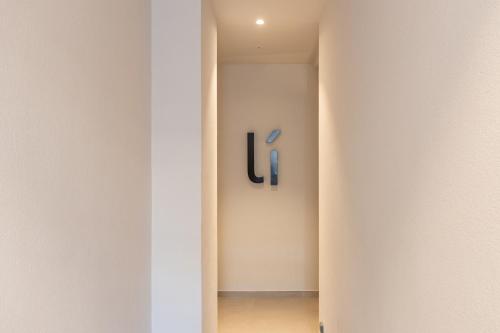 a hallway with a wall with a sign on it at Líbere Málaga Trinidad in Málaga