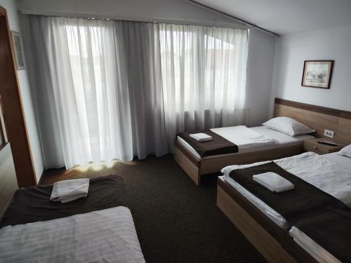 a hotel room with two beds and a window at TIM rooms in Velika Gorica