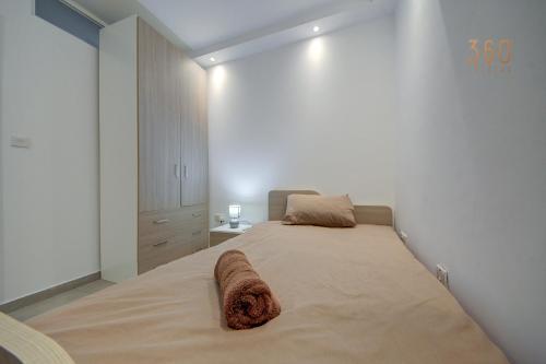 a bedroom with a large bed with a night stand at Modern 3BR home with Balcony in Central Msida by 360 Estates in Msieraħ