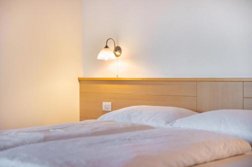a bedroom with a bed with a headboard and a lamp at Residence Linderhof in Naz-Sciaves