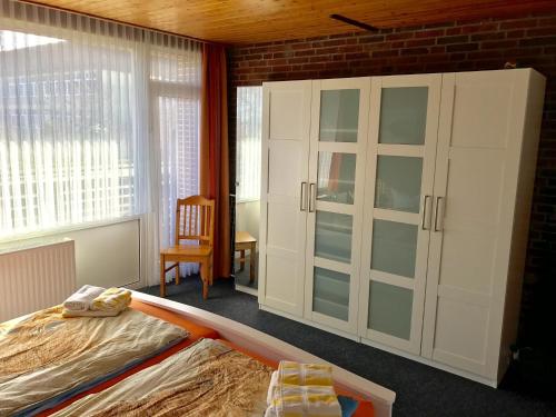 a bedroom with a bed and a large window at Ferienwohnung Haus Rügen auf Borkum in Borkum