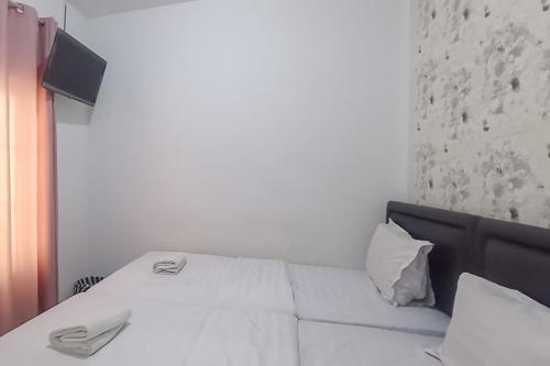 a bedroom with a bed with white sheets and pillows at Kulonprogo Guesthouse Mitra RedDoorz in Temon
