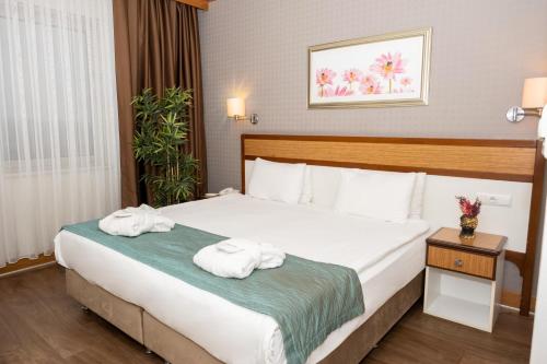 a hotel room with a bed with towels on it at Euro Park Hotel Bursa in Bursa