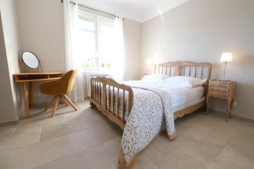 une chambre avec un lit, un bureau et une fenêtre dans l'établissement vacation rental with pool and poolhouse, close to arles in moulès- sleeps 8, à Moulès