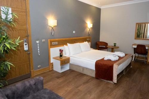 a hotel room with a bed and a couch at Euro Park Hotel Bursa in Bursa