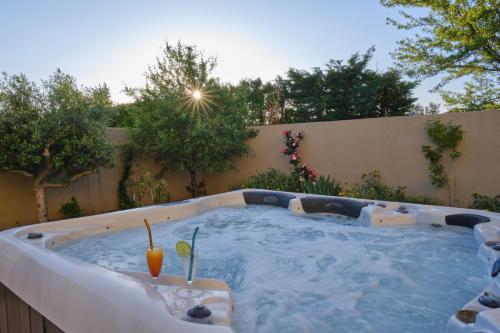 a hot tub in a backyard with a drink in it at charming villa with heated pool, 14 people, located in aureille, near les baux de provence, in the alpilles in Aureille