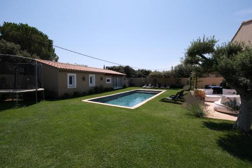 a yard with a swimming pool and a house at charming villa with heated pool, 14 people, located in aureille, near les baux de provence, in the alpilles in Aureille