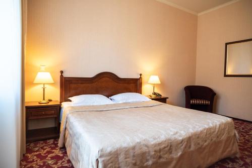 a hotel room with a bed and two lamps at Solva Resort Medical & SPA in Polyana