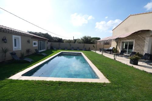 a swimming pool in the yard of a house at charming villa with heated pool, 14 people, located in aureille, near les baux de provence, in the alpilles in Aureille