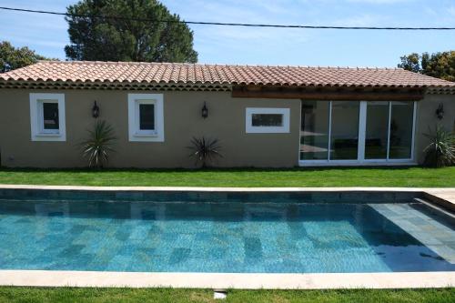a house with a swimming pool in front of a house at charming villa with heated pool, 14 people, located in aureille, near les baux de provence, in the alpilles in Aureille