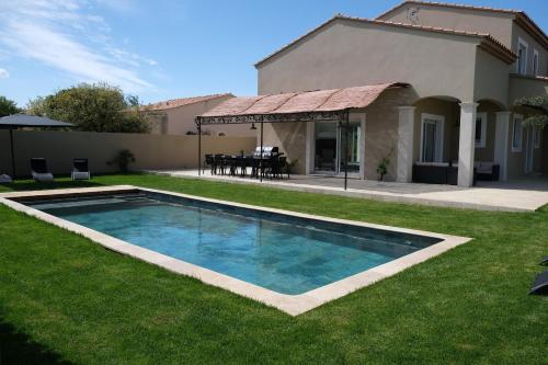 a swimming pool in the yard of a house at charming villa with heated pool, 14 people, located in aureille, near les baux de provence, in the alpilles in Aureille