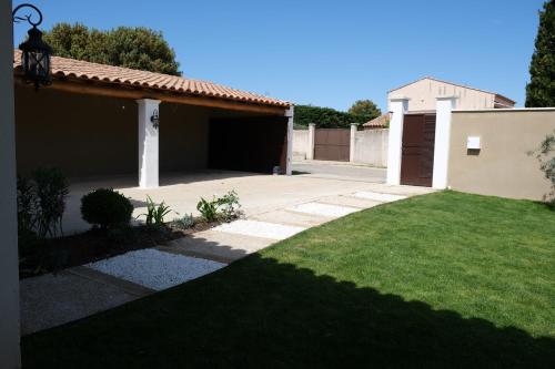 a house with a yard with a garage at charming villa with heated pool, 14 people, located in aureille, near les baux de provence, in the alpilles in Aureille