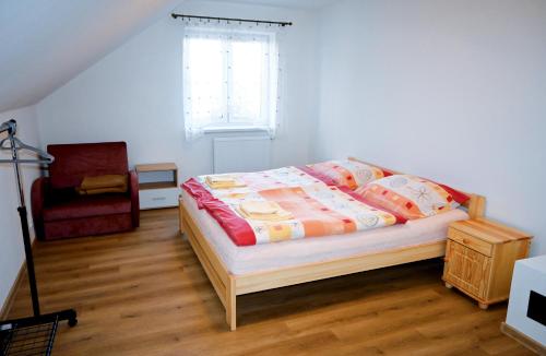 a bedroom with a bed and a window and a chair at Chata Jožka in Vyšné Ružbachy