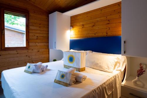 a bedroom with a bed with towels on it at Club del Sole Adriano Family Collection in Punta Marina