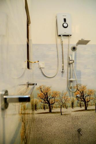a shower on a wall with a picture of trees at Samanmali Apartment in Unawatuna