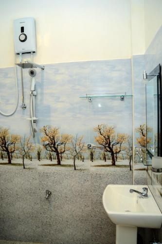 a bathroom with a shower and a sink and trees at Samanmali Apartment in Unawatuna