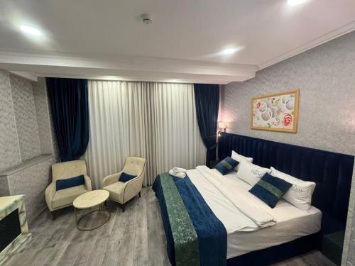 a hotel room with a bed and two chairs at Essam Deluxe Hotel in Baku