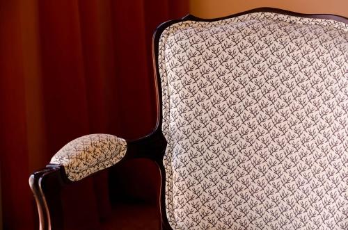 a chair sitting in a room with a red curtain at Hotel Principe Real in Lisbon