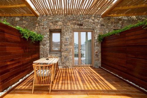 a patio with a table and chairs in front of a building at Mileo in Kalo Livadi