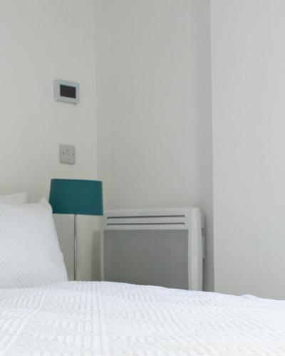 a bedroom with a white bed and a blue chair at Oak Lodge in Welling