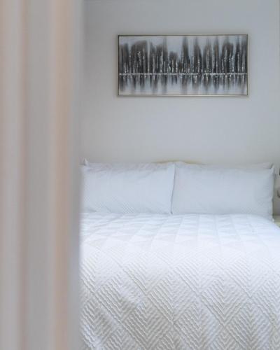 a bedroom with a white bed with a picture on the wall at Oak Lodge in Welling