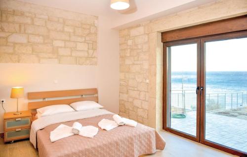 una camera da letto con un letto con vista sull'oceano di Petrina Villa A a Kastrí