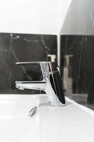 a chrome faucet on a white sink in a bathroom at Oak Lodge in Welling