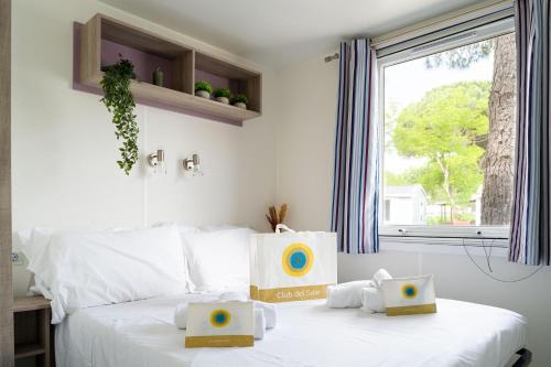 a bedroom with a bed with two boxes on it at Club del Sole Adriano Family Collection in Punta Marina