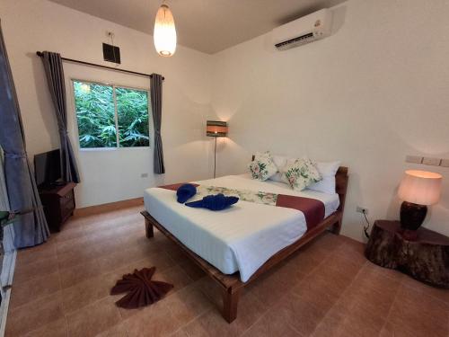 a bedroom with a bed in a room with a window at Zabit Bungalow in Ko Lanta