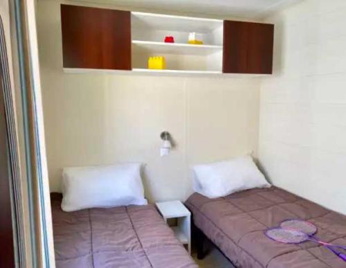 une petite chambre avec deux lits et une armoire dans l'établissement Camping 5 étoiles - Piscine - eeaiba, à Saint-Georges-dʼOléron