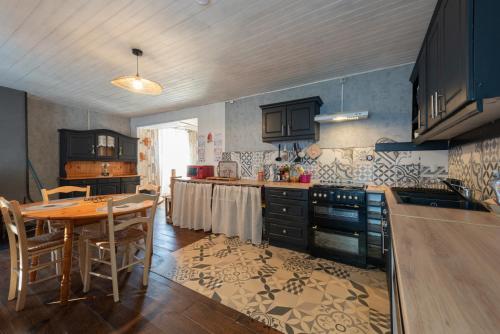 a kitchen with a table and a dining room at Gite La Pondique in Escot