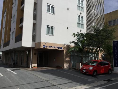 a red car parked in front of a building at Hotel Peace Island Miyakojima in Miyako Island