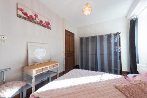 a bedroom with a bed and a table and a desk at Gite La Pondique in Escot