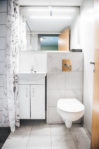 a white bathroom with a toilet and a sink at Vågslidtun Hotel in Vågsli