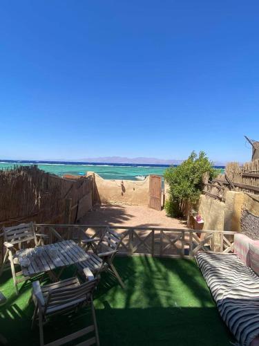 a patio with a table and chairs and the ocean at Luna House Asala Beach in Dahab