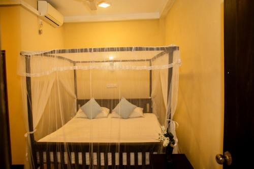 a bed with a canopy in a room at Samanmali Apartment in Unawatuna