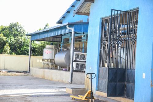 a blue building with a machine in front of it at Sangare Gardens- Book Now Enjoy Free Farm Tour in Mweiga