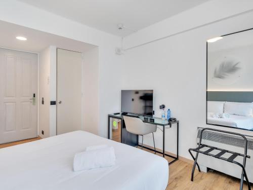 a white bedroom with a bed and a sink at B&B HOTEL Alba in Alba