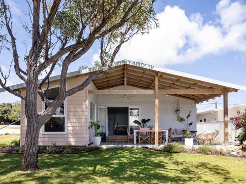 a white house with a wooden pergola at Stylish Shack Falcon Bay in Wannanup