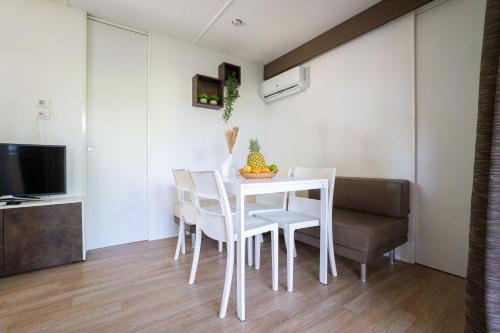 a dining room with a white table and chairs at Club del Sole Adriano Family Collection in Punta Marina