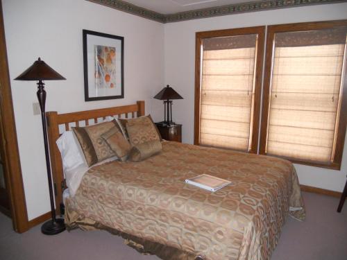 a bedroom with a bed and two windows at LandMark Inn at the Historic Bank of Oberlin in Oberlin