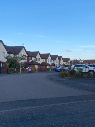 a parking lot with a bunch of houses and cars at Harbury Lodge in Scotstoun West Station