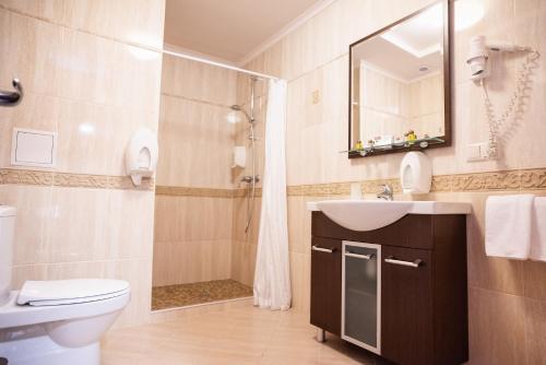 a bathroom with a toilet and a sink and a shower at Solva Resort Medical & SPA in Polyana
